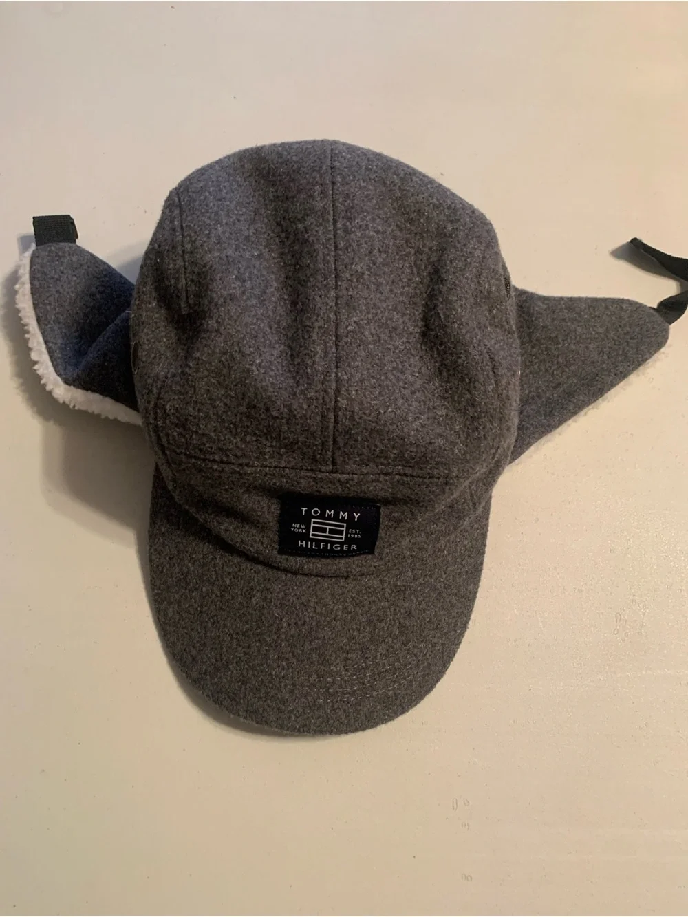Tommy Hilfiger fleece winter cap featuring fold-down ear flaps with white sherpa